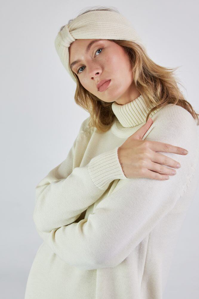 A girl wearing a knit headband and a turtleneck dress with raglan sleeves