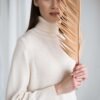 A knitted merino wool dress with set-in sleeves and a roll neck. Handmade in Lithuania