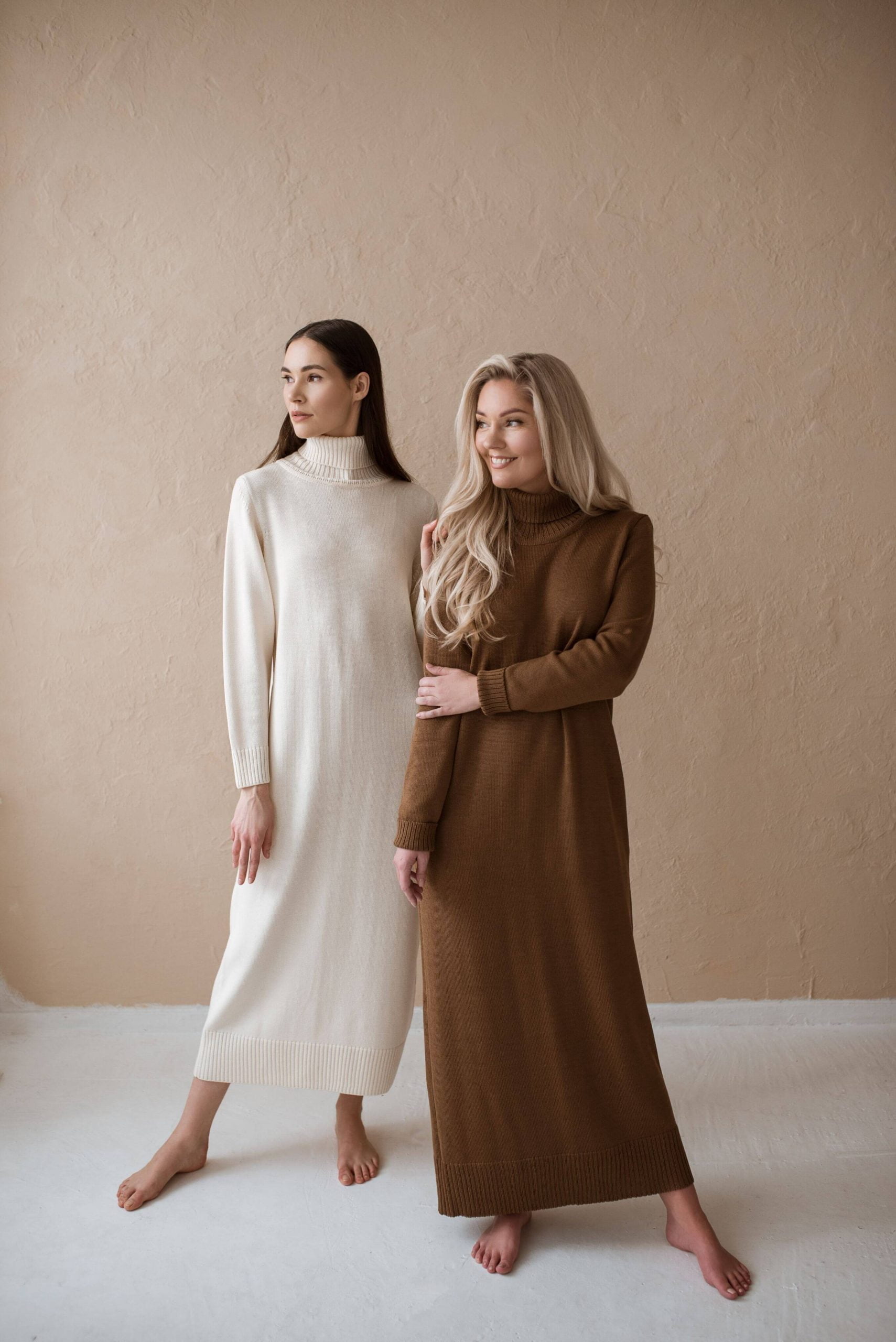 Two girls in merino wool dresses with a turtleneck. One is natural white and the other is brown. Made with a manual knitting machine