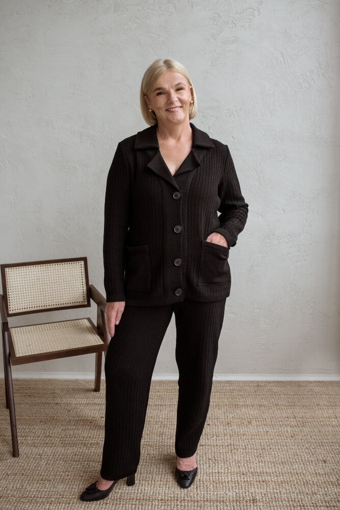 Women's knit suit made of merino wool. The top part is a cardigan with front pockets. The pants are made in a matching pattern. Tapered.