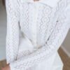 A knit button-up shirt-like blouse in a lace pattern. Made of 100% wool