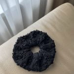 Subtle merino wool scrunchie knitted in a delicate eyelet pattern.
