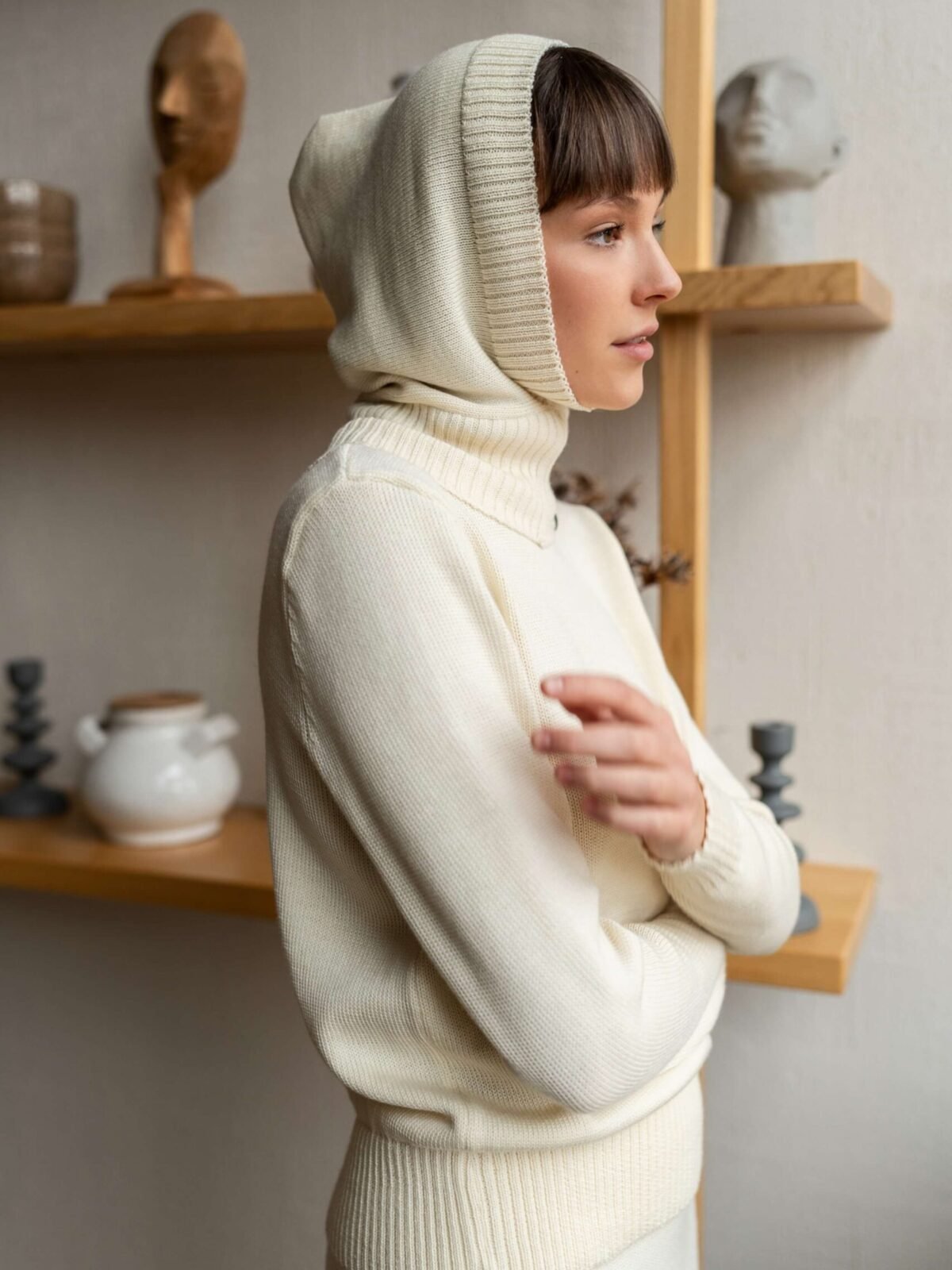 An outfit of a knitted hood and a matching turtleneck sweater paired with a column skirt.