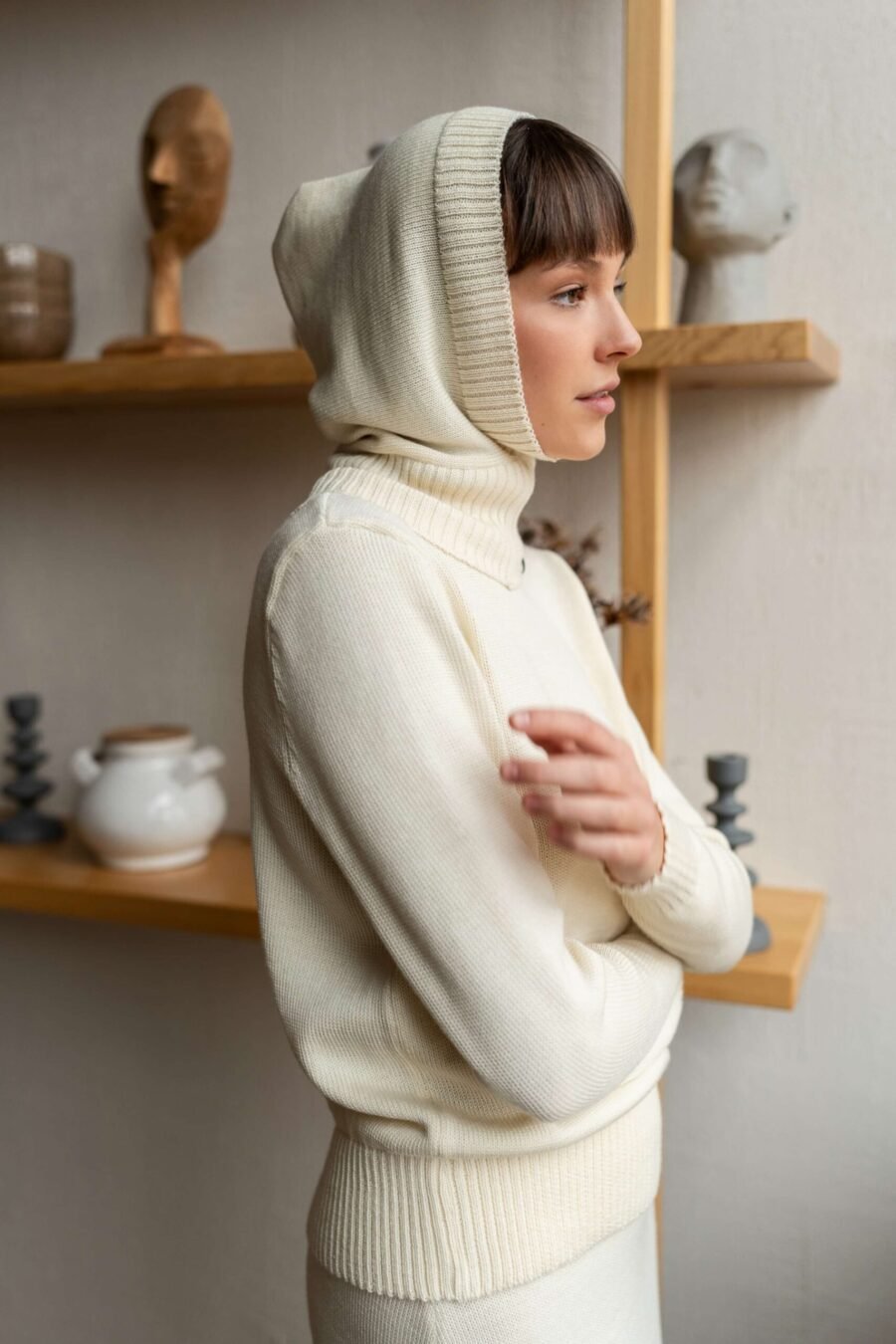 An outfit of a knitted hood and a matching turtleneck sweater paired with a column skirt.