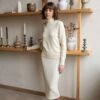 Minimalist and elegant combo of a merino wool sweater with a high neck and a slim-fit knitted skirt.