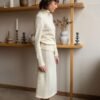 Two-piece set of a natural white turtleneck sweater and a matching skirt featuring an elastic waistband.